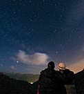 A couple enjoys watching the night sky